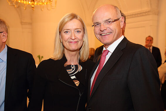 Ein Mann und eine Frau in eleganter Kleidung posieren auf einem Fest